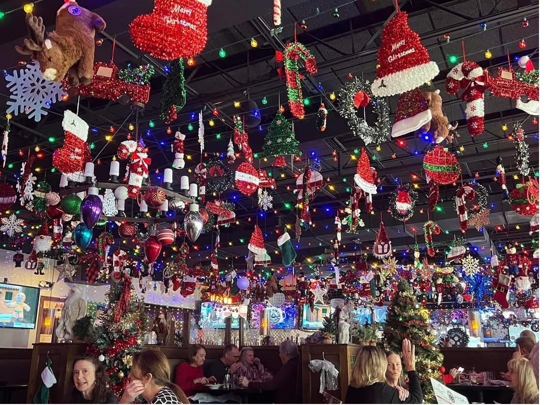 Ceiling packed with ornaments and lights at a Jolly Elf holiday popup